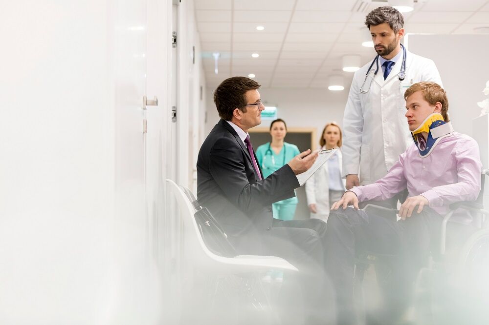 Injured patient talking to his doctor and lawyer.